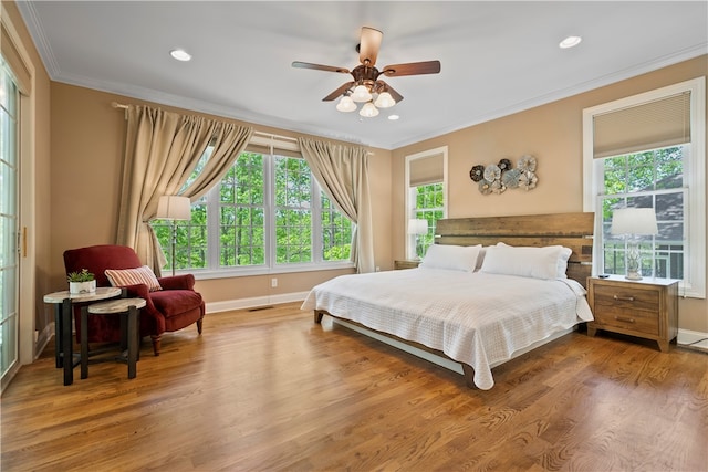 bedroom with ornamental molding, ceiling fan, and hardwood / wood-style flooring