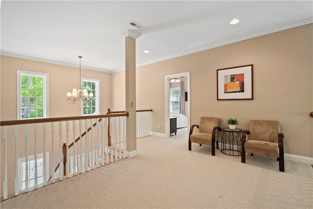 sitting room with light carpet, ornamental molding, decorative columns, and a chandelier