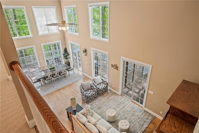 living room with a towering ceiling, plenty of natural light, and hardwood / wood-style floors