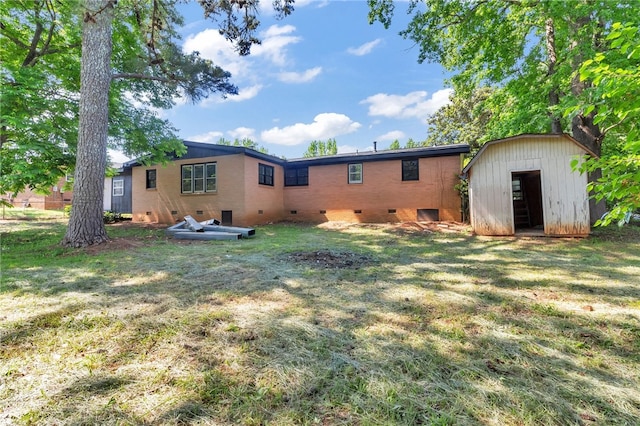 rear view of house with a yard and a shed