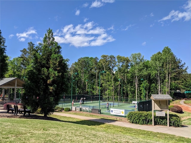 view of community featuring a lawn and tennis court