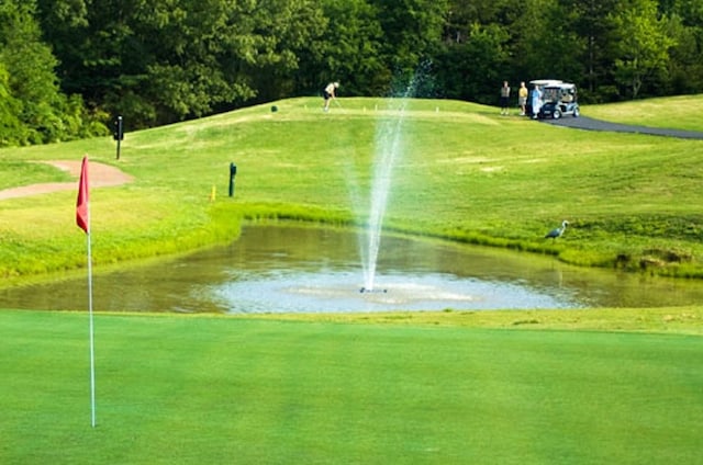 surrounding community with a lawn and a water view