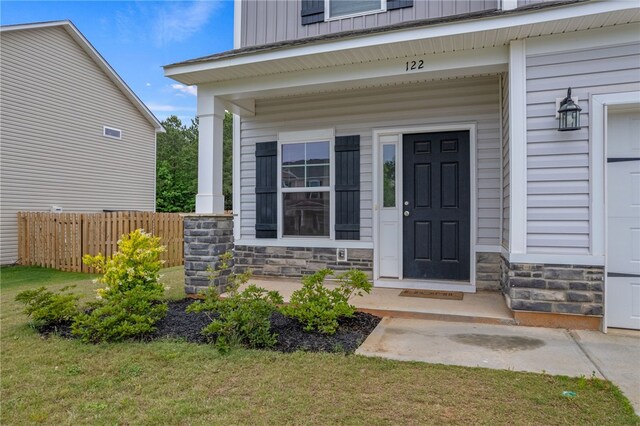 property entrance with a lawn and a porch