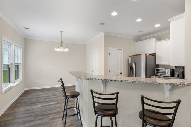 kitchen featuring a kitchen breakfast bar, white cabinets, wood-type flooring, and stainless steel fridge with ice dispenser