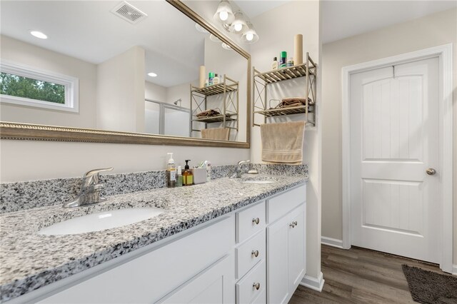 bathroom with vanity, hardwood / wood-style flooring, and a shower with shower door