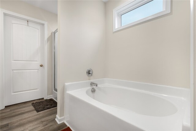 bathroom with hardwood / wood-style flooring and separate shower and tub