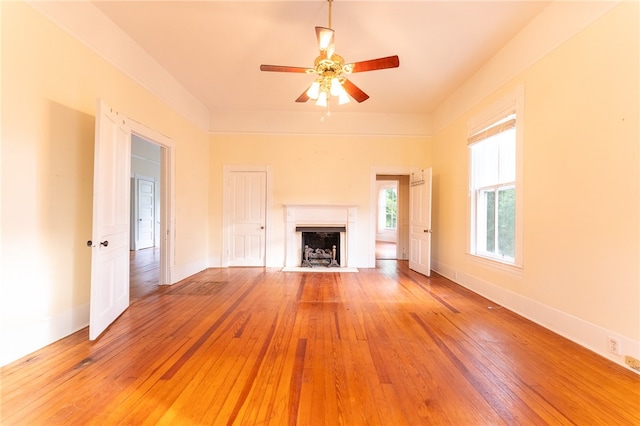 unfurnished living room featuring ceiling fan and hardwood / wood-style flooring