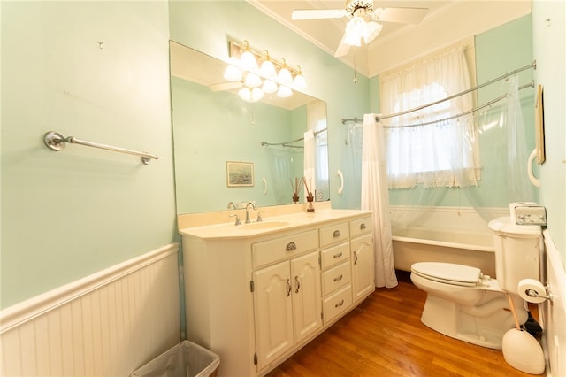 full bathroom featuring wood-type flooring, ornamental molding, shower / bath combo with shower curtain, vanity, and toilet