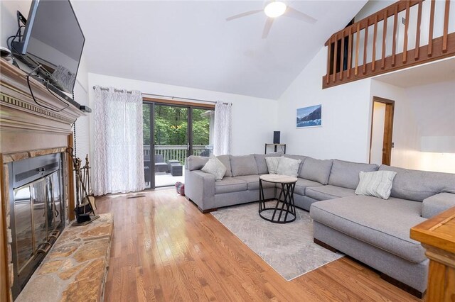 living room with ceiling fan, a fireplace, hardwood / wood-style floors, and high vaulted ceiling