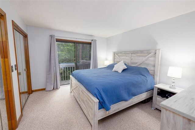 carpeted bedroom featuring a textured ceiling and access to exterior