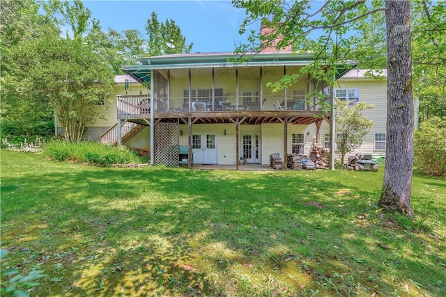 rear view of house with a patio, a yard, a sunroom, french doors, and a deck