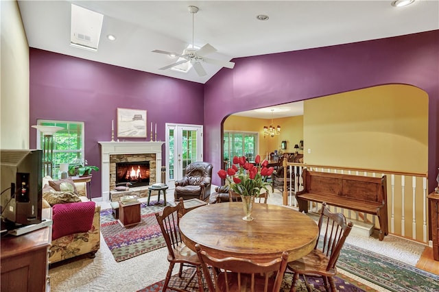 dining area featuring ceiling fan with notable chandelier, hardwood / wood-style floors, high vaulted ceiling, and plenty of natural light