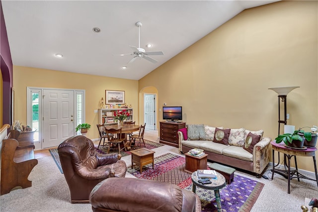 living room featuring ceiling fan, light carpet, and vaulted ceiling