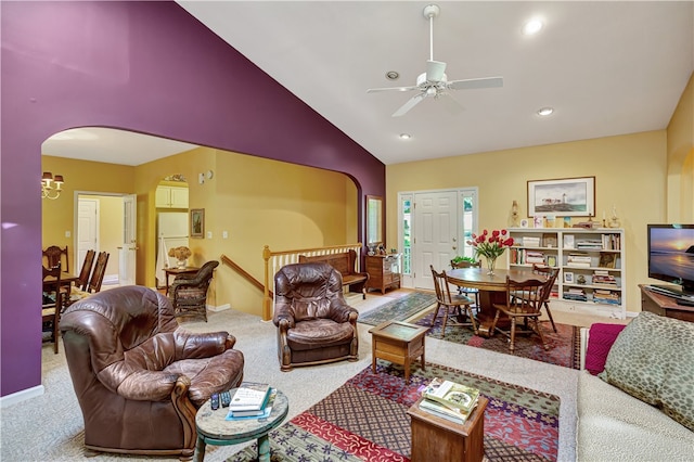 carpeted living room with ceiling fan and high vaulted ceiling