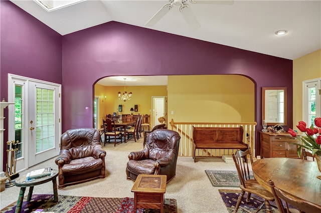 living room with ceiling fan with notable chandelier, carpet flooring, and high vaulted ceiling