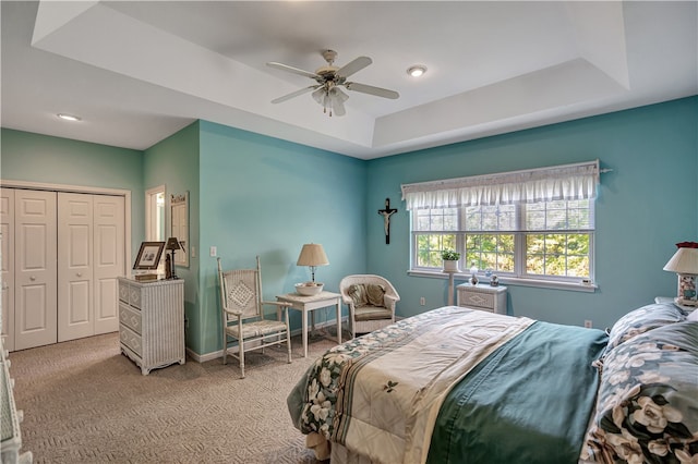 bedroom featuring carpet, ceiling fan, and a tray ceiling