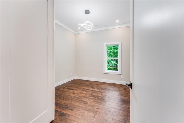 spare room with crown molding and dark hardwood / wood-style floors