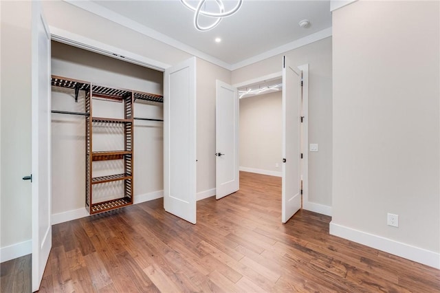 unfurnished bedroom with a closet, baseboards, and wood finished floors