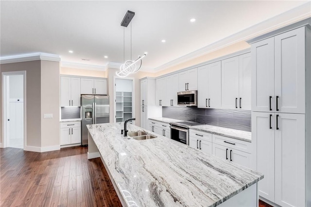 kitchen with decorative backsplash, dark wood-style floors, a large island, stainless steel appliances, and a sink