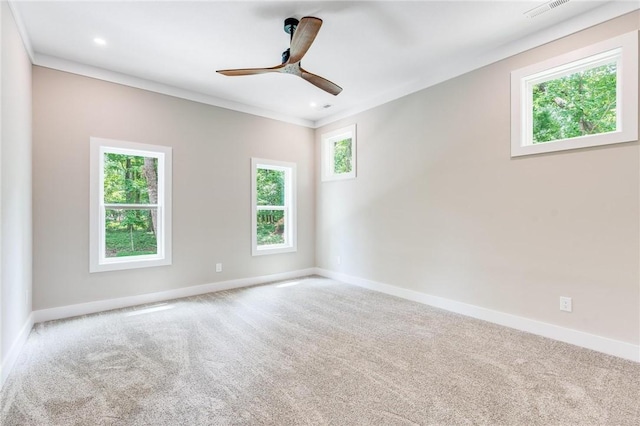 spare room featuring light colored carpet, ornamental molding, and ceiling fan