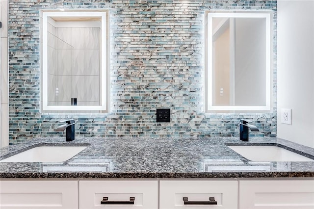 kitchen with white cabinetry, sink, and dark stone counters