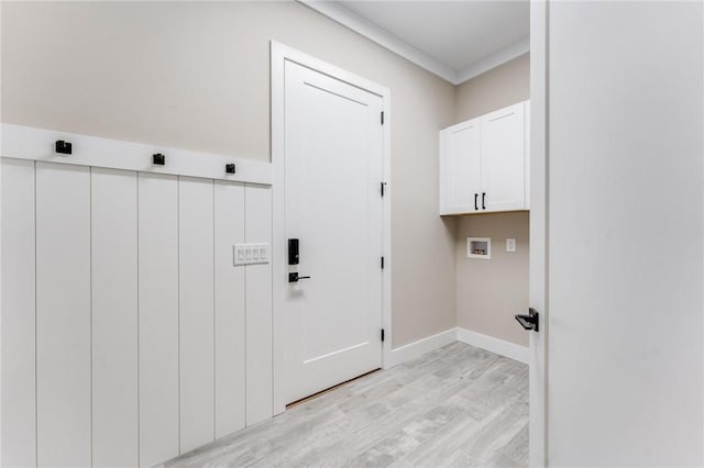 clothes washing area featuring cabinets, ornamental molding, hookup for a washing machine, and light wood-type flooring