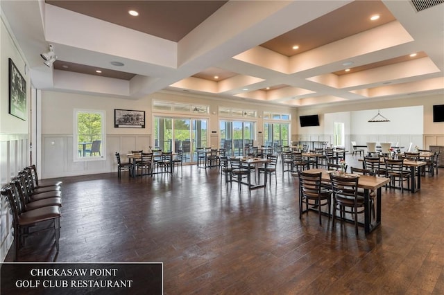 dining space with dark wood-type flooring and a raised ceiling