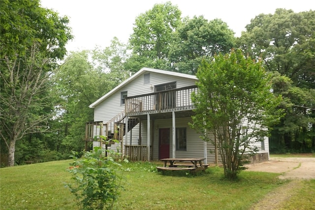 rear view of house with a yard and a wooden deck