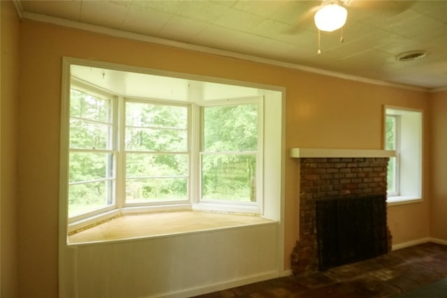 living room with a brick fireplace, plenty of natural light, ornamental molding, and ceiling fan