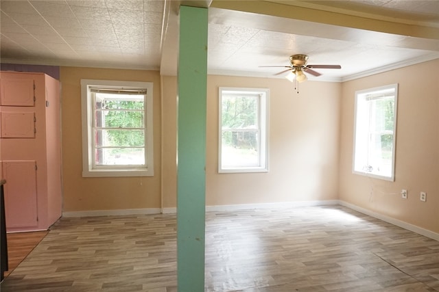 unfurnished room featuring wood-type flooring, ceiling fan, a healthy amount of sunlight, and crown molding