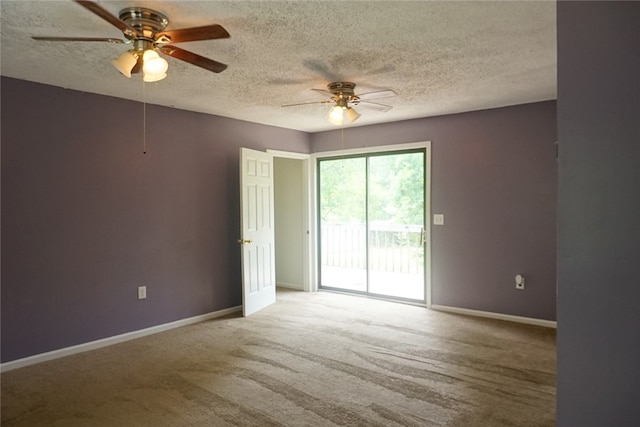 carpeted spare room with a textured ceiling and ceiling fan