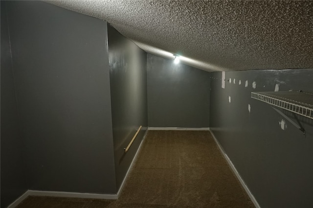 corridor featuring carpet floors, a textured ceiling, and vaulted ceiling