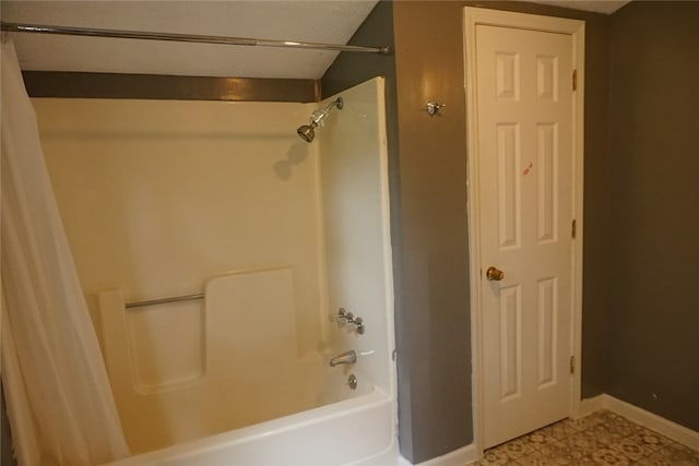 bathroom featuring a textured ceiling, shower / tub combo with curtain, and tile patterned flooring