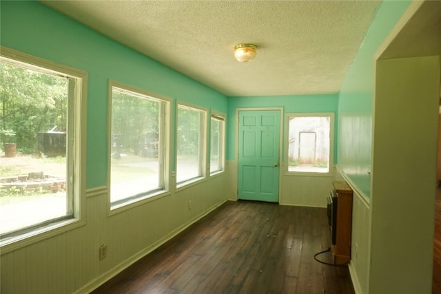 doorway with a textured ceiling and dark hardwood / wood-style floors