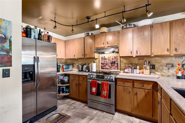 kitchen with light tile patterned flooring, stainless steel appliances, and tasteful backsplash