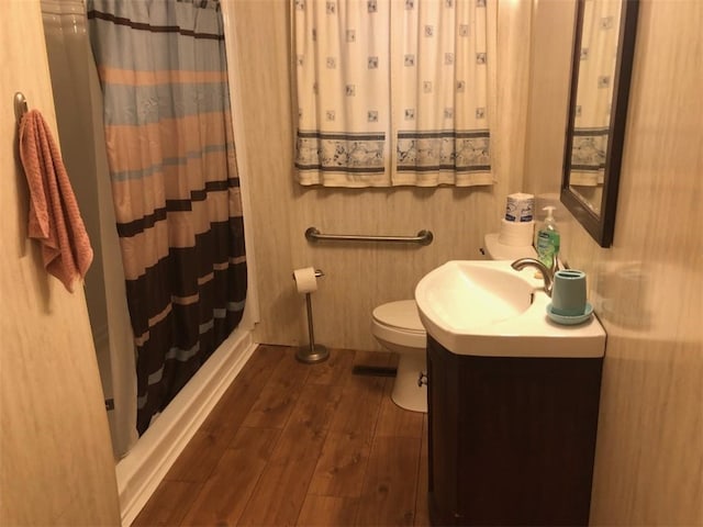 bathroom featuring vanity, hardwood / wood-style flooring, toilet, and curtained shower