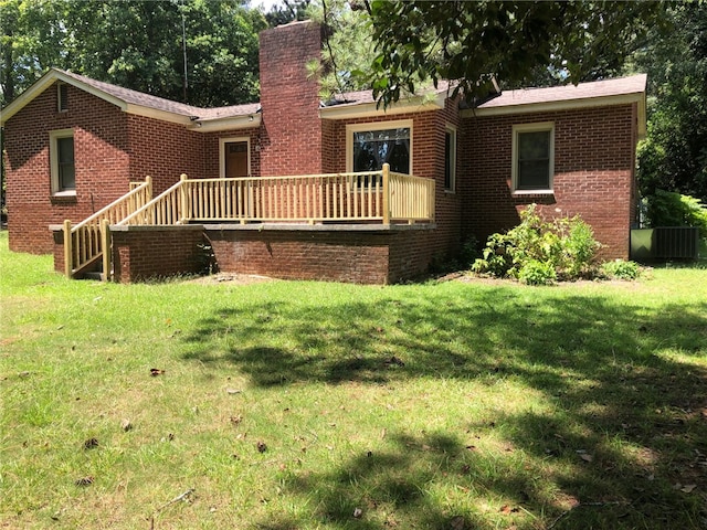 rear view of property featuring cooling unit and a yard