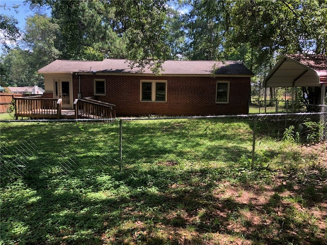 rear view of property featuring a wooden deck and a lawn