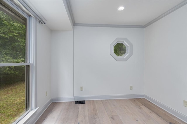 unfurnished room with ornamental molding, a healthy amount of sunlight, and wood finished floors