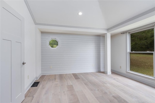 spare room featuring light wood-type flooring, visible vents, and baseboards