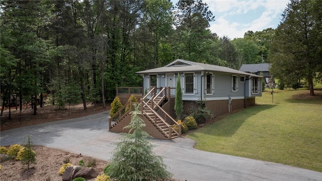 view of front of home with stairway, a front lawn, driveway, and covered porch