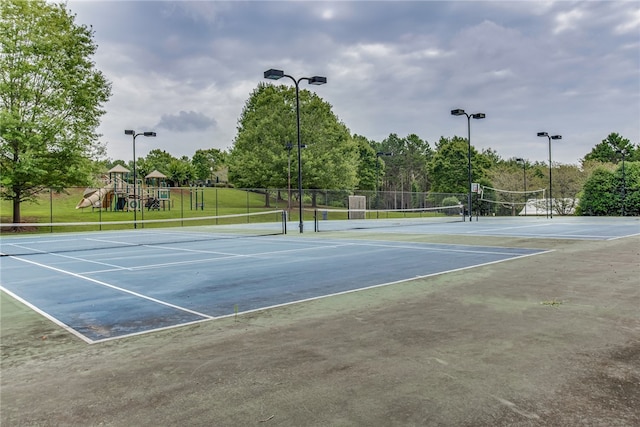 view of tennis court featuring a playground