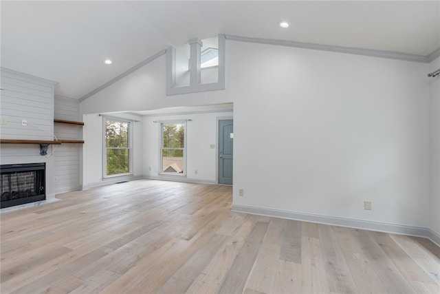 unfurnished living room with light wood-type flooring, a fireplace, ornamental molding, and high vaulted ceiling