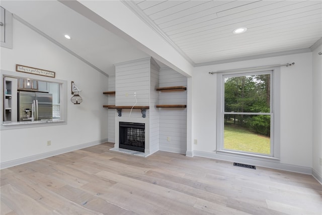 unfurnished living room with ornamental molding, vaulted ceiling, light hardwood / wood-style floors, and a fireplace