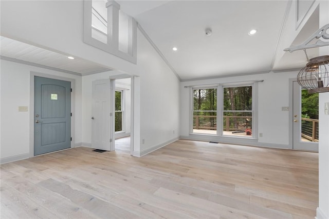foyer entrance with lofted ceiling, light wood-type flooring, and a healthy amount of sunlight