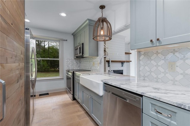 kitchen featuring a sink, gray cabinets, stainless steel appliances, backsplash, and visible vents