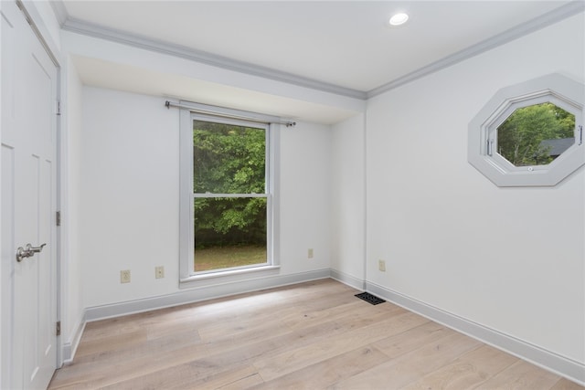 spare room with ornamental molding, light hardwood / wood-style floors, and a wealth of natural light