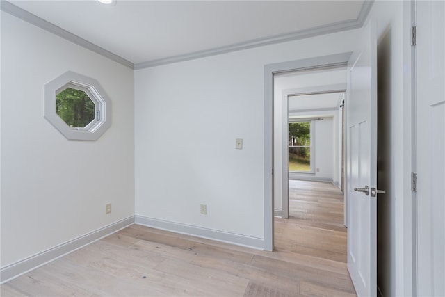 empty room featuring ornamental molding and light wood-type flooring