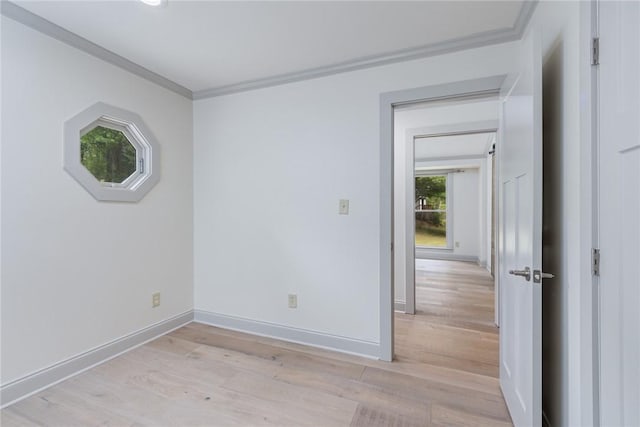 unfurnished room featuring baseboards, ornamental molding, and light wood-type flooring
