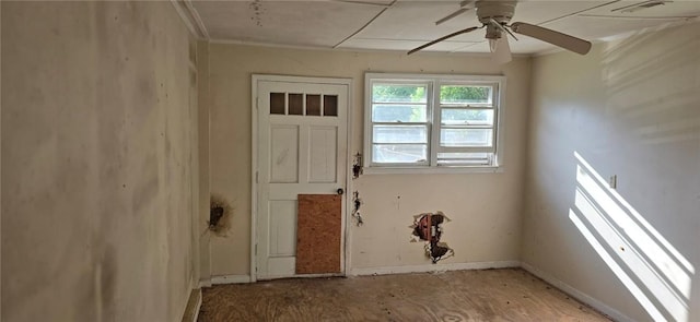 doorway to outside with ceiling fan and baseboards